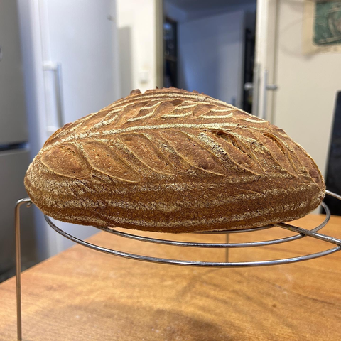 A sourdough bread, seen from the side, with its pretty leaf pattern showing.