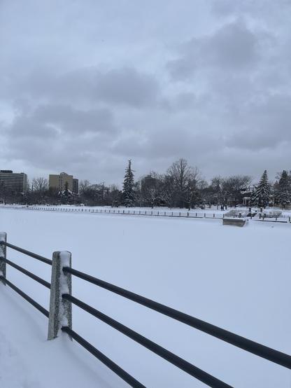 The snow covered Rideau Canal, the sky is grey and cloudy