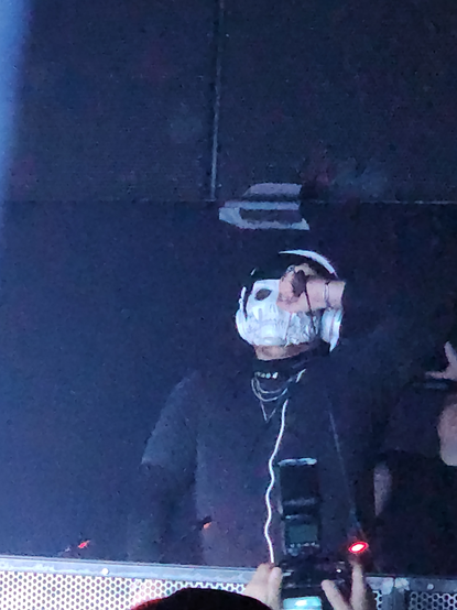 Reaper speaking into a microphone while DJing at Kingdom