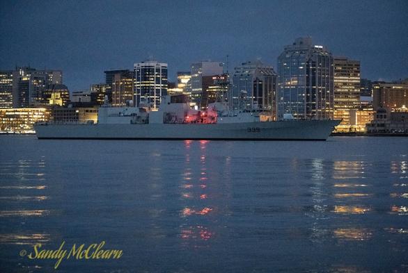 Warship with buildings in the background.