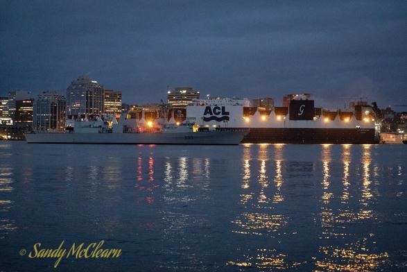 Warship passing container ship.