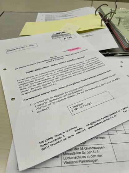 Foto eines Ausdrucks der Anfrage hier: https://www.stvv.frankfurt.de/download/A_124_2022.pdf, liegend auf einem anderen Dokument und einem Aktenordner