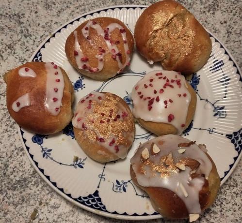The same decorated buns on a blue and white plate but only 6 remain.