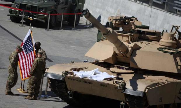 US soldiers stand with Polish and US flags near M1/A2 Abrams tank in Kielce, Poland, on 5 September 2022.