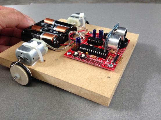 A simple robot platform cut from MDF driving dowel wheels with o-ring tires. The motors are attached to the platform using cable ties, and the circuit board, battery holder and other components can easily be screwed into place.