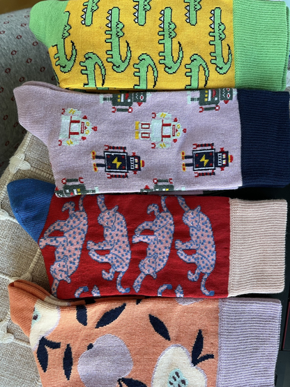 Bunte Socken mit verschiedenen Motiven wie Robotern, Leoparden, Krokodilen