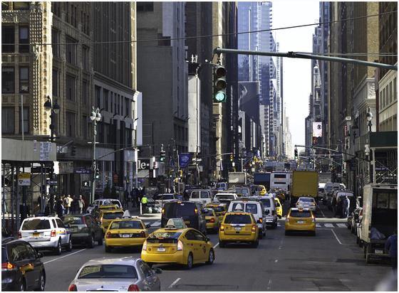A New York daytime street scene dominated by the ubiquitous yellow New York taxi.