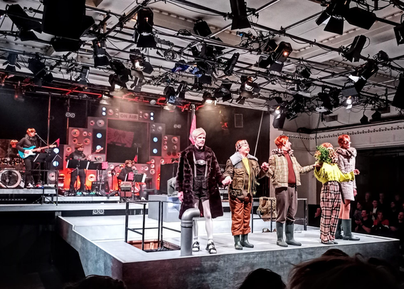 Auf der Bühne der Neuköllner Oper die 5 Darsteller:innen und im Hintergrund die Band