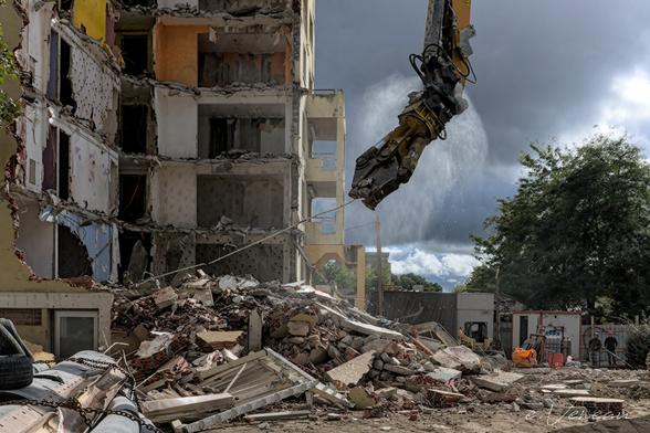 A demolition machine guts a building whose structure of the old housing is discovered