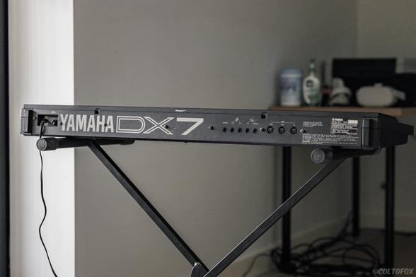 Rear view of a musical synthesizer keyboard labelled 'YAMAHA DX7'.