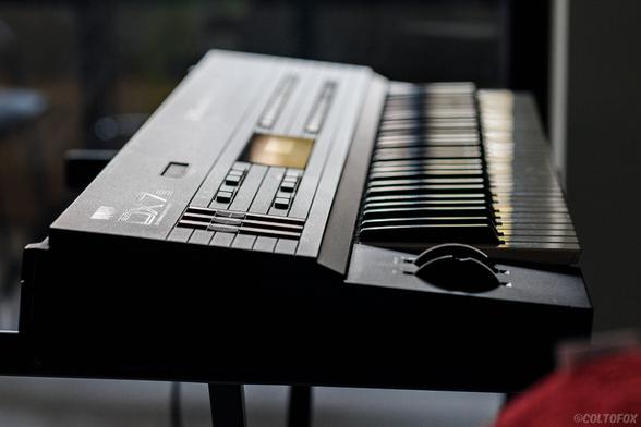 Side view of a Yamaha DX7S musical synthesizer keyboard, camera focused on the faders.