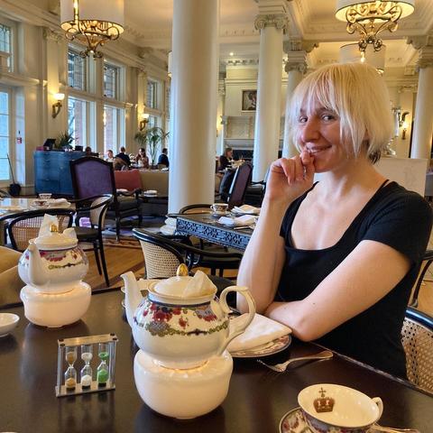 It’s a Sandra, with the big open dining room visible behind them and a teapot in front of them. They have a playful happy look.