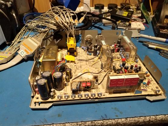 A General Instrument CFT-2100 set-top box, disassembled, with a logic analyser connected to the ROM socket.