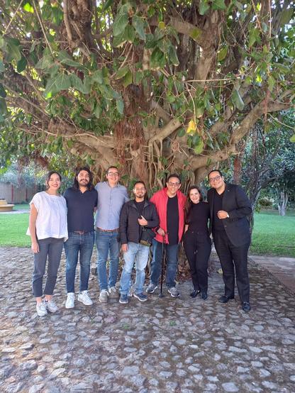 Mi grupo de escritura narrativa en español, posando delante de un árbol de amate de gran tamaño en una propiedad de Tepoztlán.
