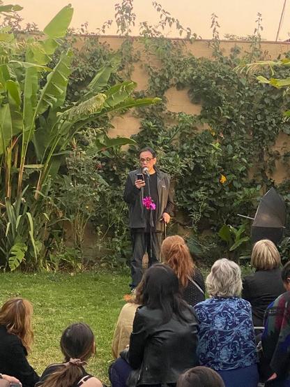 El escritor Alberto Chimal lee, en un jardín de Tepoztlán, minificciones en inglés, dentro de un evento de micrófono abierto en Under The Volcano
