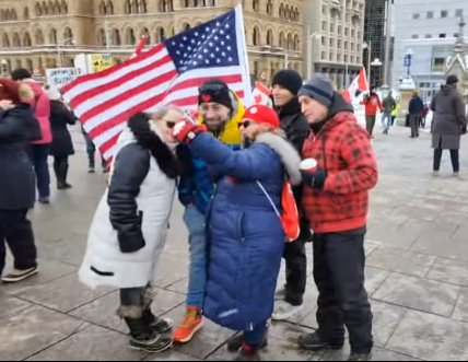 Freedumb Convoy idiots taking a selfie with a US flag on Parliament Hill, 28 January 2023.