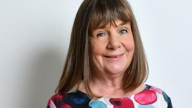 Close-up of Julia Donaldson smiling at the camera. She is in front of a white wall.