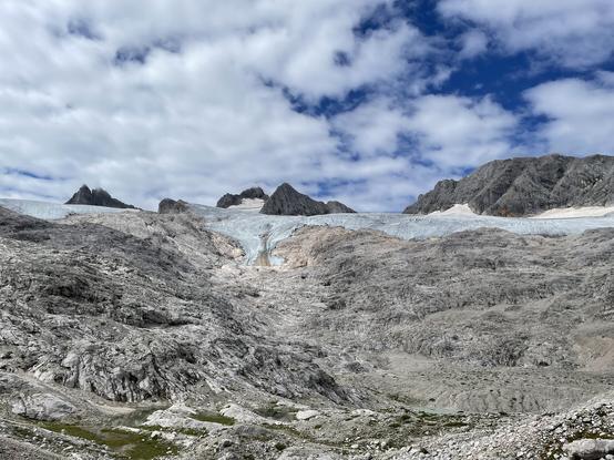 Retreating Glacier: bare rocks in the foreground, some glacial ice and tall Mountains (Dachtsein among them) in the background
