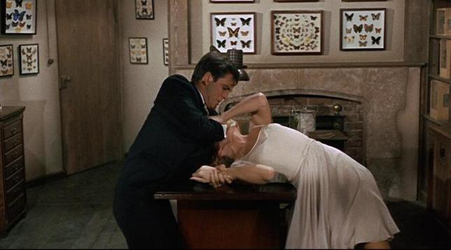 A man drugging a woman in front of his butterfly collection.