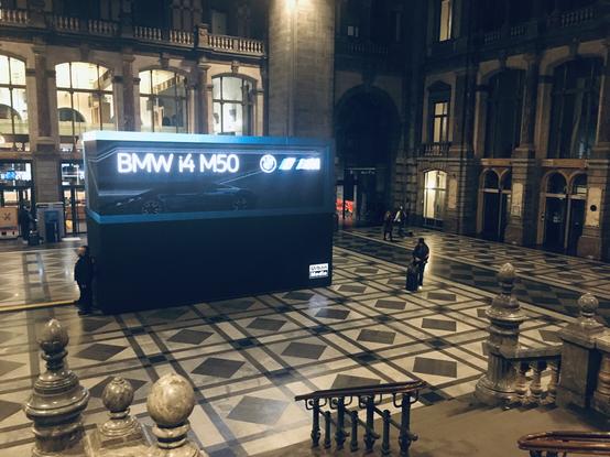 Grote kubusvormige reclamezuil met LED-schermen in de centrale hal van station Antwerpen Centraal