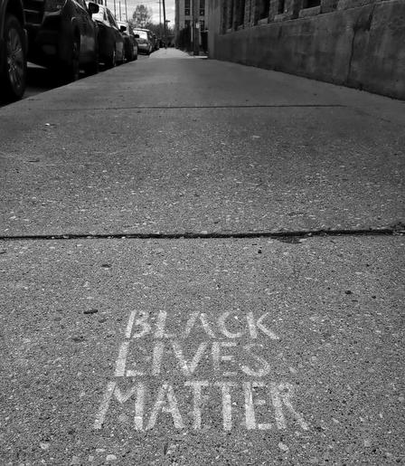 A Black Lives Matter stamp etched into a Milwaukee, WI sidewalk.