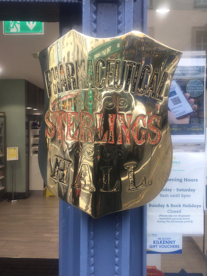 A golden shield shaped sign with residual colours just visible.