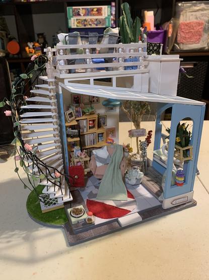 Front view of dollhouse described previously in the first post of this thread.changed the rug making it round and red with a gray and white zigzag pattern across the middle. Also made a red handbag with a chain strap.