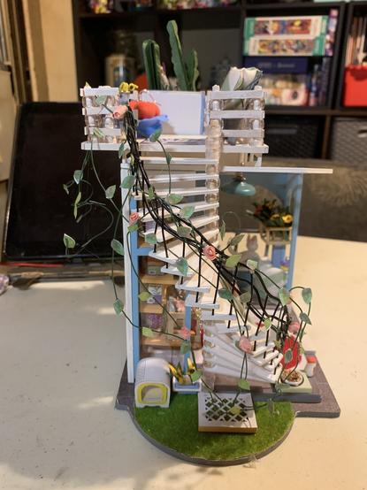 Left side of dollhouse showing the spiral staircase with the rose vines wrapped around it
