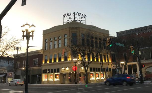 A photo of the sun rising behind a building on the public square of the town of New Philadelphia, Ohio.
