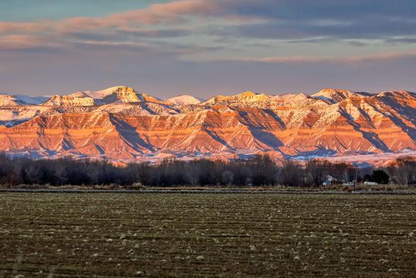 Book Cliff mountain range with a dusting of snow at sunset.