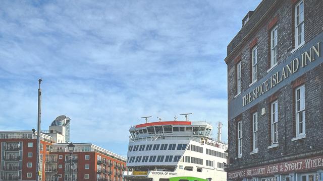 Photograph of the Wightlink car ferry Victoria of Wight with Gunwharf Quay flats to the left and The Spice Island Inn pub on the right.