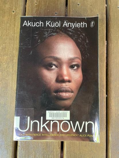 The cover of the book 'Unknown' features the author Akuch Kuol Anyieth on the cover. She looks toward to reader.