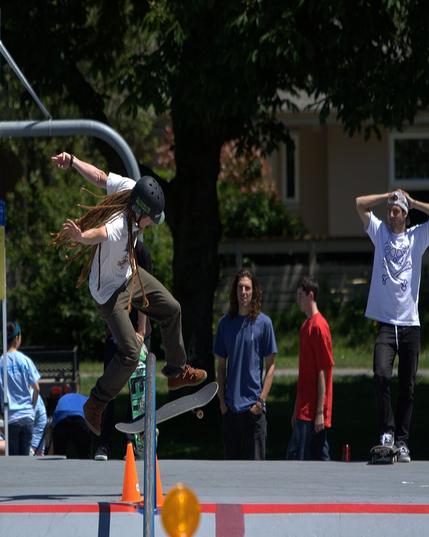 TJ Watt, with skateboard in mid air, after jumping over obstacle.