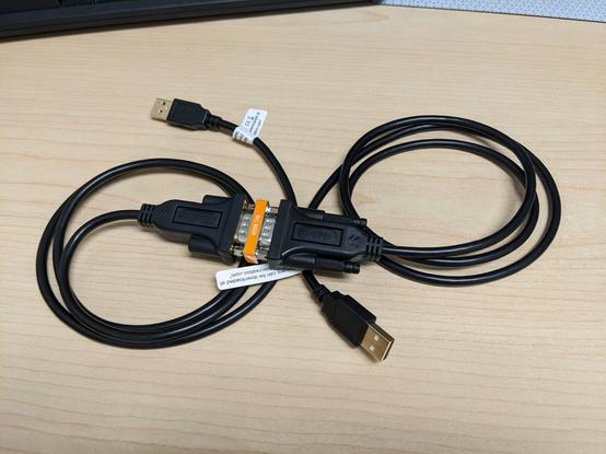 A pair of USB serial cables attached together with a null modem adapter.