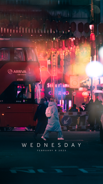 A woman walks by in the lights of Chinatown.