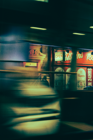 A man caught in the reflection of a bus window.