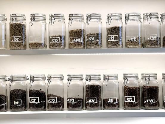A selection of coffee beans in Mason jars in two rows on shelves