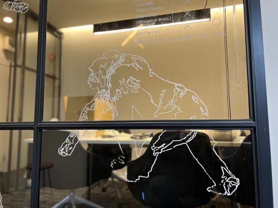 On the office window is line art of a gorilla walking