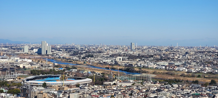 A view of the Tama River between Tokyo and Kawasaki, Japan. A stadium is in the foreground.