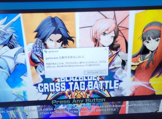 An error message displayed in Japanese. It roughly translates to "failed to boot game.exe." Being displayed over the title screen of Blazeblue Cross Tag Battle.
