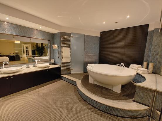Huge bathroom with double sinks and a tub large enough to do laps in. Sauna (not pictured) is on the opposite side.