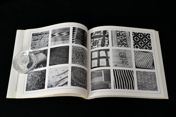 A spread from "Autobiography", a square format book where each page has nine photographs laid out in a 3×3 grid. All photos of the book are taken in LeWitt's studio, home, or from his collection of reference photos. This spread deals with textile and patterns, woven or sewn, featuring closeups of cushions, bed spreads, tapestry and carpet, among others.