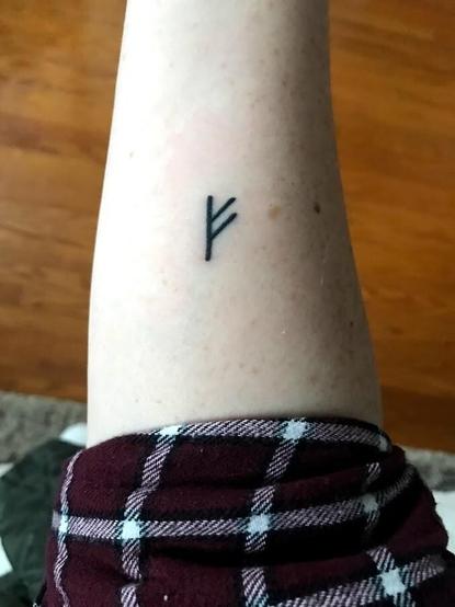 Fehu tattooed on forearm
