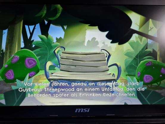Abfotografierter Bildschirm. Ein Moment aus dem neuesten Monkey Island. Zu sehen ist eine verlassene Parkbank. Darunter die Worte "Vor vielen Jahren, genau an diesem Tag, starb Guybrush Threepwood an einem Unfalltod, den die Behörden später als Ertrinken bezeichneten."