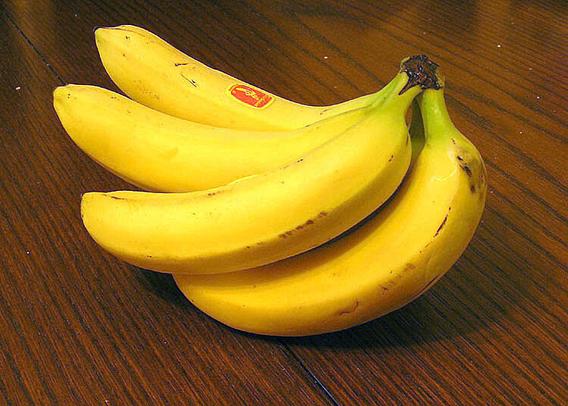 A bunch of bananas on a wooden table

Caption: That's not what I meant when I said "these bananas taste divine"...