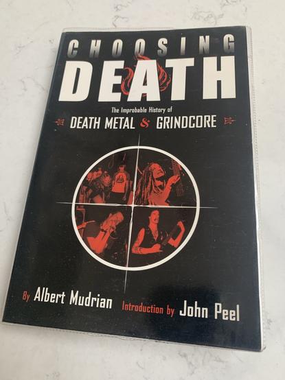 A photo of a book called Choosing Death: The Improbable History of Death Metal & Grindcore by Albert Mudrian