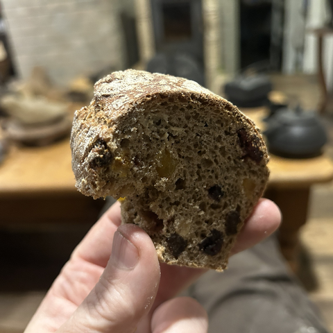 It's a rye bread, so even these medium ones need to cool off for at least two hours before you can cut them. This is a closeup of one thick slice of bread (with a bite already taken out of it.) The crust is thick and beautiful and the crumb is full of small air pockets. Not an easy thing with rye bread but the starter had been doing its fermenting prework for almost 14 hours, at room temperature.  There is also so much fruit in it - and that combination of rye bread and dried fruit is incredibly good.