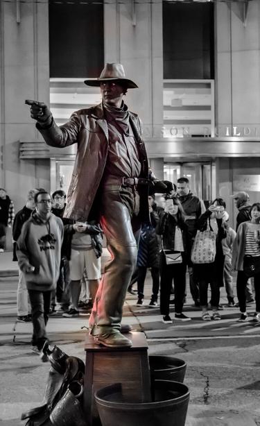 Living statue posing on the streets of downtown Toronto Canada at night.