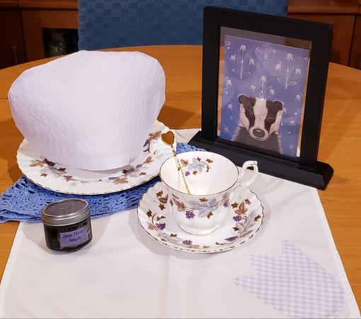 A tea tableau in blue and lavender and a badger. The tea is Jazz Mint.