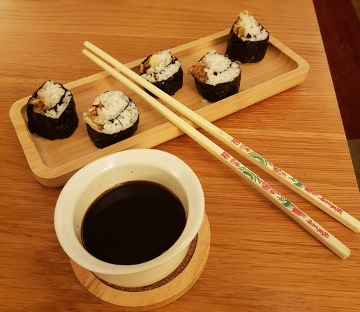 Pic of DIY vegan sushi with chopsticks and bowl of soy sauce.